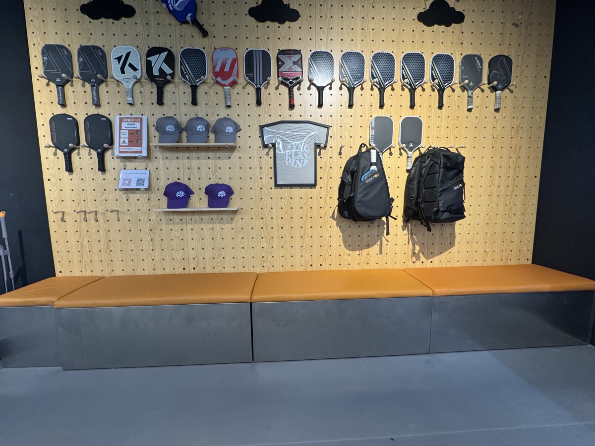 Pro shop wall with paddles, caps, t-shirts and backpacks for sale